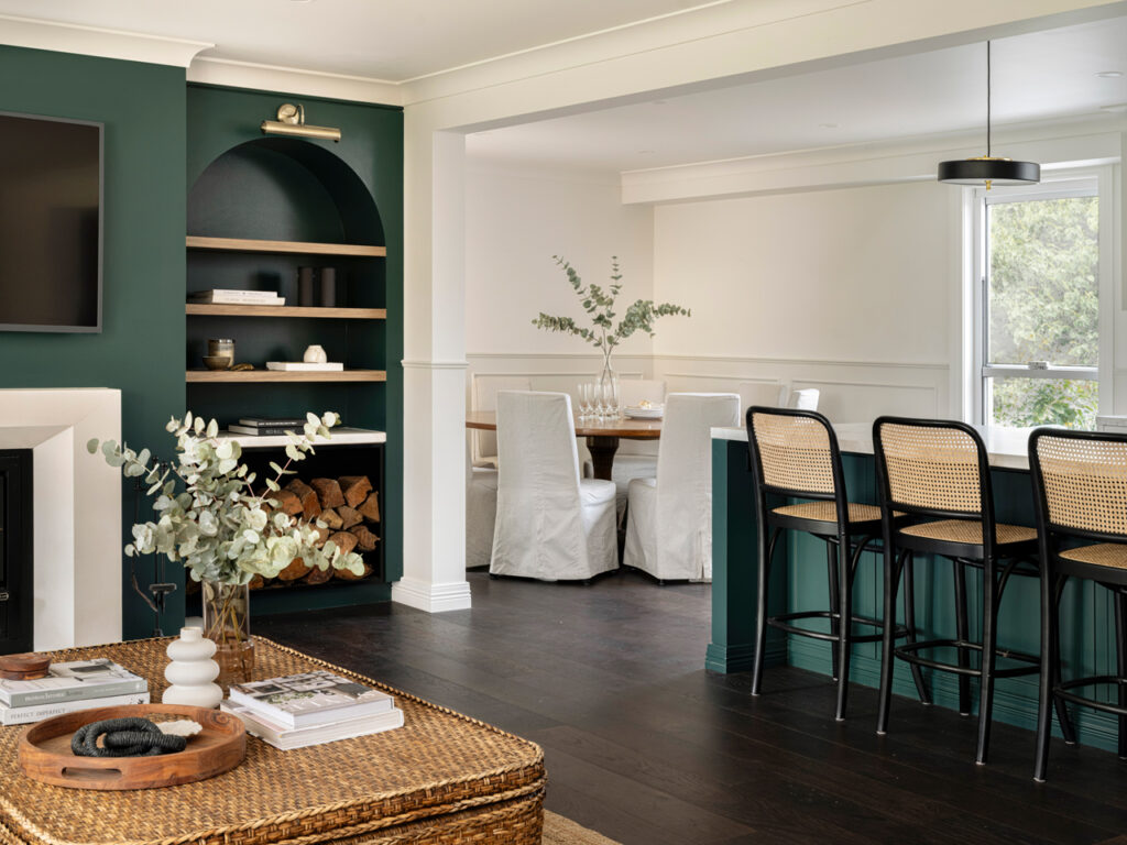 Renovated Southern Highlands home interior with dark timber floors, green feature walls, and open-plan kitchen and dining area crafted by Precision Build — a trusted Southern Highlands builder.