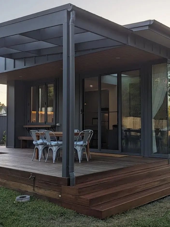 View of timber deck and steel-framed New Build completed by a Southern Highlands builder, showing the outdoor dining area and modern pergola.